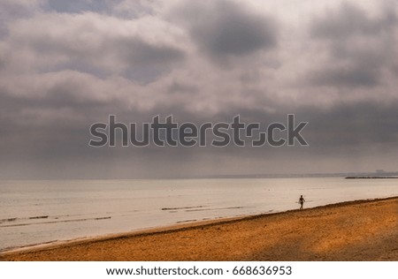 A lonely silhouette walking on the beach