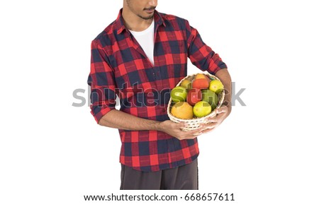 Midsection of farmer holding a basket of fruits (orange, manga, avocado and khaki) isolated in white background