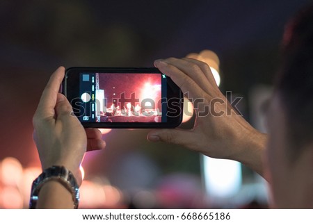 Audience using Smartphone with photo app in phone to take picture and video on concert