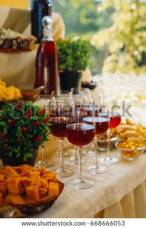 Glasses with wine stand on table with cheese and other snacks