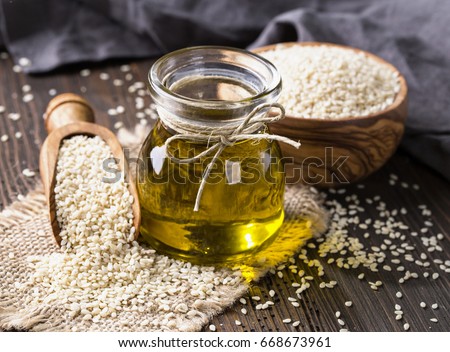 Sesame oil in glass and seeds Royalty-Free Stock Photo #668673961