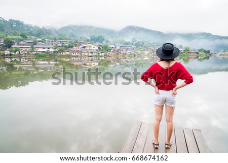 Woman stand in front of lake and watch the village 2