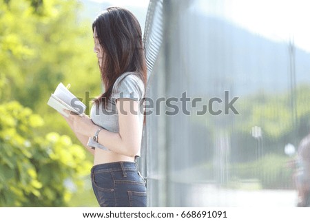 young woman relax covered her face by White book in nature 