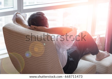 Easy relax business man lifestyle after work at hotel sitting hands behind head for happy businessmen people Royalty-Free Stock Photo #668711473