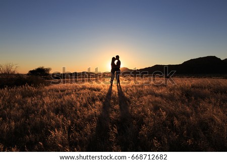 Couple kissing at african savanna landscape. Namibia, South of Africa.