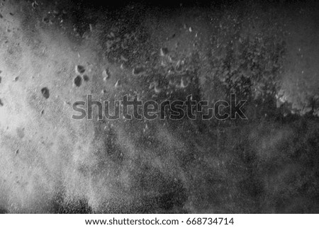 Abstract design of white powder cloud against dark background.  