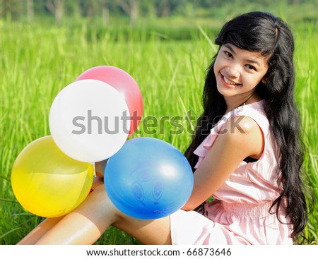 Beautiful girl smiling in pink dress looking at camera