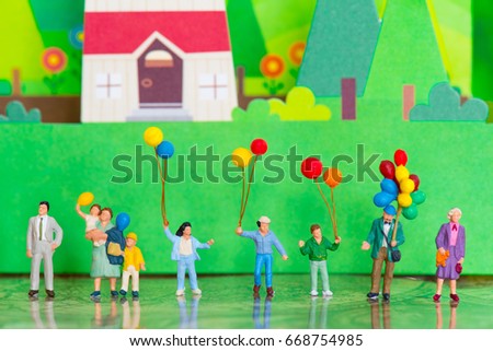 Miniature people family with the balloon using as background happy or celebrity concept.