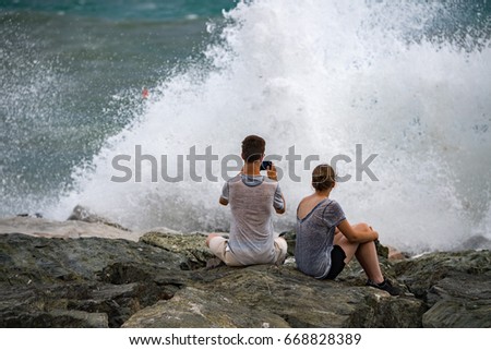 people taking pictures of Sea Storm and tempest on the coast