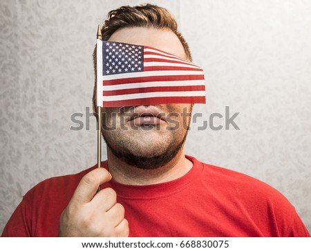 mini American flag covered face, adult man holding isolated on white wallpaper wall  background, 4 th of July, no face, eyes. unrecognizable person 
