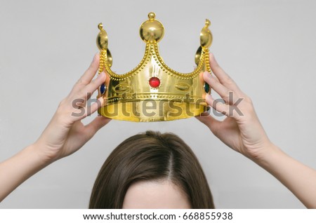 Woman girl holding above a head the golden crown. Leadership, success , queen. Royalty-Free Stock Photo #668855938