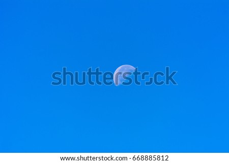 Moon in the sky on a sunny day in a bright blue sky