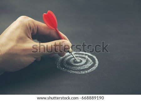 hand take a dart into the center of sketching dartboard Royalty-Free Stock Photo #668889190