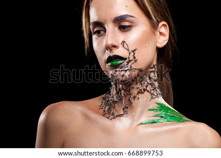 Beautiful Woman with decorative creative fashion make up on black background in studio photo. Cosmetics and extravagant makeup