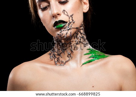 Woman with creative fashion make up on black background in studio photo. Cosmetics and extravagant makeup