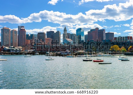 Boats traveling across Charles river with the skyline of the city in the background in Boston, America