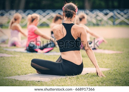 Group of women practicing yoga together during a beautiful sunny day on the meadow. Yoga in nature. Concept healthy