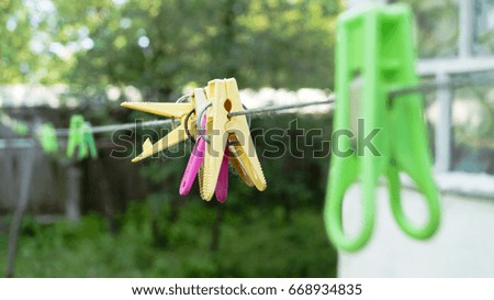 Green clothespins on a rope on a green background
