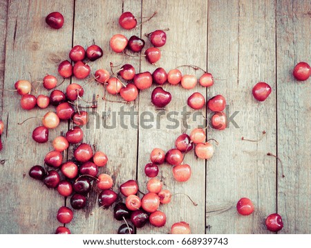 sweet cherries an old wooden background with a copy empty space for text, selective focus and toned image
