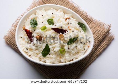 Curd Rice / Dahi Bhat OR Chawal with curry leaf, peanuts and chilli- Served in a bowl over moody background. Selective focus