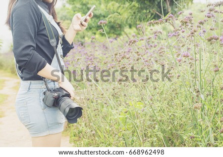 Close up young woman taking photo in a Flowers field