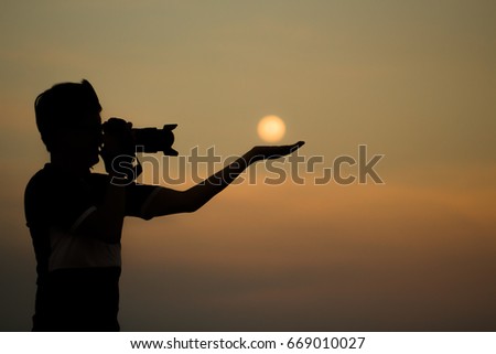 Silhouette of a photographer taking photos of a moon