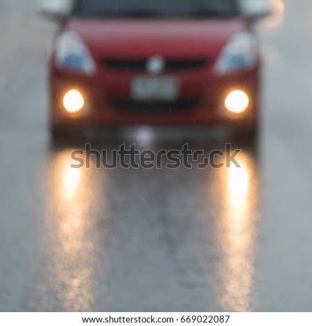 Car on a wet road with headlights, with out of focus