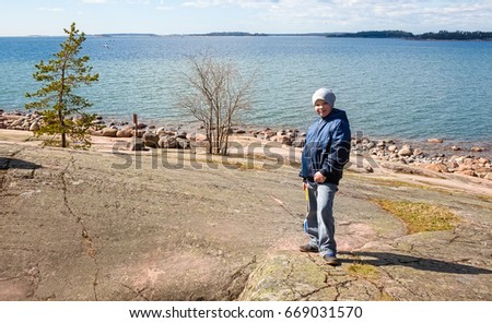 A boy stands on a stone Bank in Finland