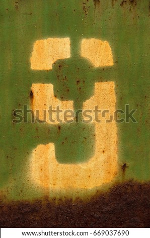 Stencil number nine on a metal wall. Yellow text number nine on metal background painted green. Inscription number nine on green background. Close-up text number nine written on rusty metal surface.