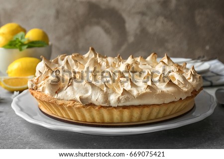 Plate with tasty lemon meringue pie on grey table, closeup