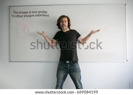A man posing as a model with a whiteboard in a funny way
