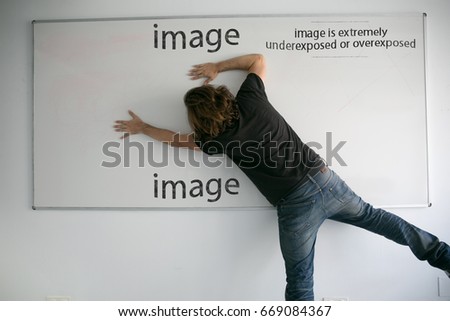 A man posing as a model with a whiteboard in a funny way