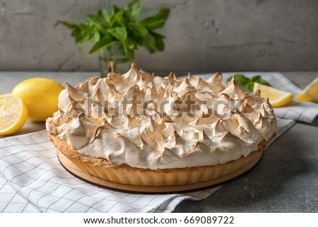 Tasty lemon meringue pie and napkin on grey table, closeup