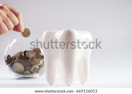 Tooth and piggy bank with coins  isolated on white background with copy space.Financial Concept Dentist Money concept. Royalty-Free Stock Photo #669156013