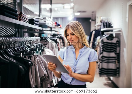 Portrait of a young woman holding a tablet in the store.