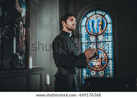 priest praying in a monastery. Picture taken in a photo studio fiction