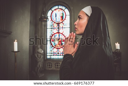 Nun praying in a monastery. Picture taken in a photo studio fiction