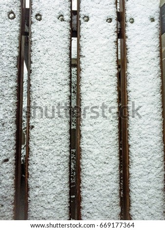 Wood bench with snow on it