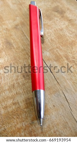 stylish red pen on wood background