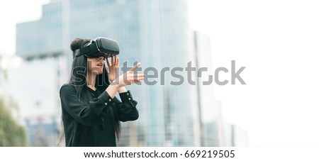 Intrigued girl, testing VR equipement, actually living and reacting in the scenario played by the out of this virtual world. New digital media Augmented and Virtual Reality 360 video and 3D video