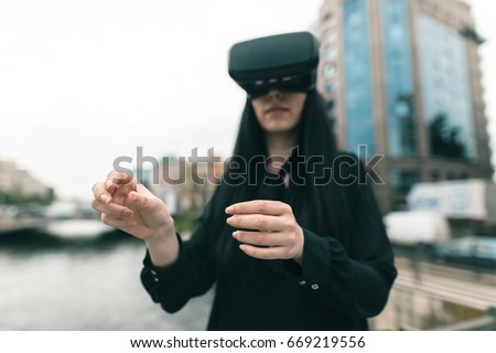 Brunette game tester finally testing the latest augment reality producing equipement the VR headset using her hands in the virtual life app. Virtual Reality 360 video and 3D video app with VR glasses