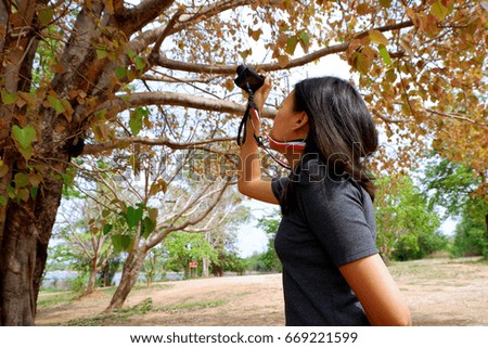 Asian woman photographer taking pictures in nature
