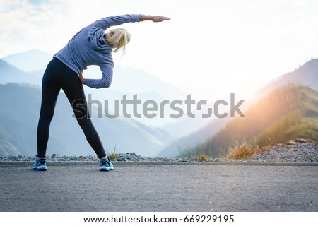 Athlete at the top of the mountain doing workout Royalty-Free Stock Photo #669229195