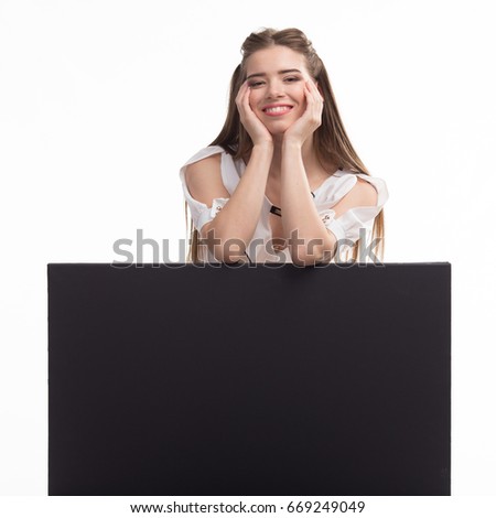 Young happy woman portrait of a confident businesswoman showing presentation, pointing placard black background. Ideal for banners, registration forms, presentation, landings, presenting concept..