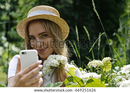 A girl in a straw hat takes a selfie