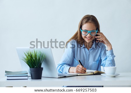 Study, student, office, work, woman in glasses behind laptop writes in notebook.