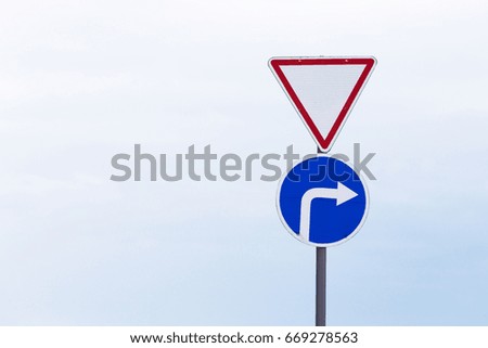 Road sign and pointer on a bright sky background