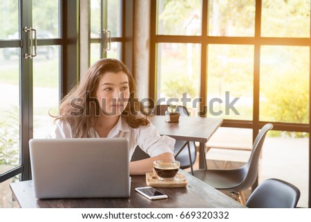 Portrait of  mixed race long hair beautiful woman work with laptop and glass of black coffee  in thinking and looking.
