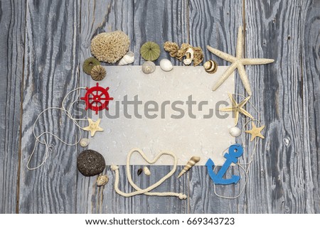 Marine background with shells and starfish and a piece of paper on a wooden table 