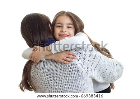 little girl smiles and hugs her mother close-up